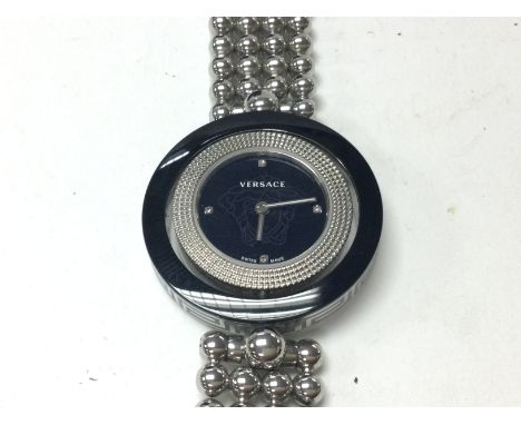 A Versace ladies watch with spinning bezel and round face with black dial. Comes with box. Postage B