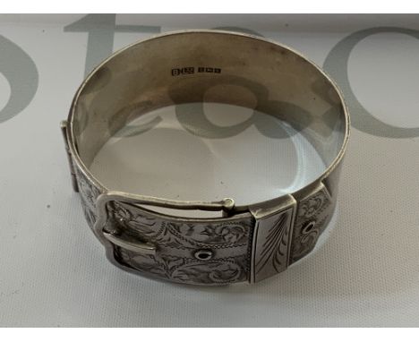 A heavy hallmarked silver buckle design bangle, with silver pill box. (A) 69g.