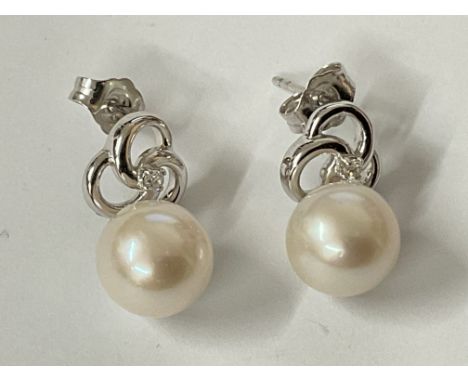 Pair of 9ct white gold round freshwater Pearl and diamond pinwheel earrings. R/C diamonds 0.05ct. Postage category A.