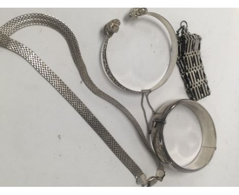 Two silver bangles a silver necklace and a silver gate bracelet.
