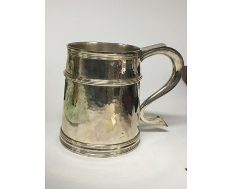 A Quality silver tankard of 18th century design with a shaped handle and hammered pattern sides with raised turning London ha