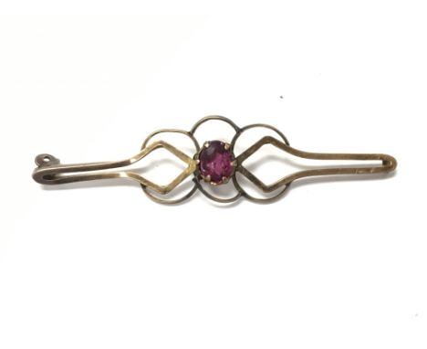 A 9ct gold brooch set with a small ruby. 1.60g
