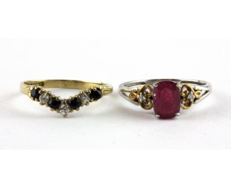 A 9ct yellow gold and 925 silver ring set with an oval cut ruby and diamond set shoulders, and a further a 9ct gold wishbone 