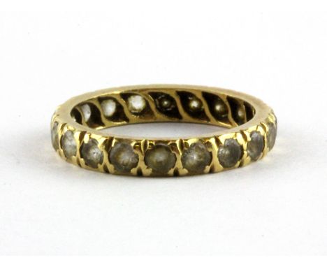 A yellow metal (tested minimum 9ct gold) stone set full eternity ring, (L).