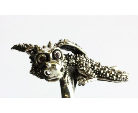 A 925 silver and marcasite dragon shaped ring, with ruby set eyes, L. 4cm, (P.5).