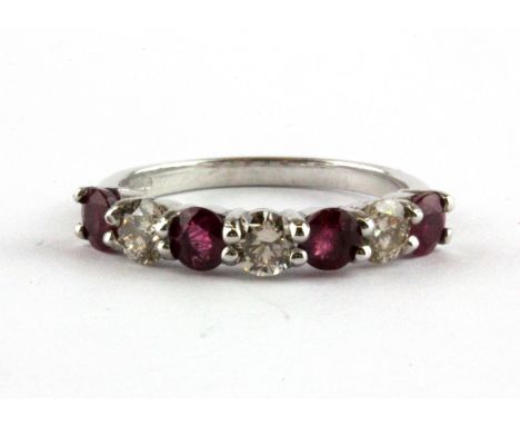 An 18ct white gold (stamped 750) half eternity ring set with brilliant cut rubies and diamonds, (M).
