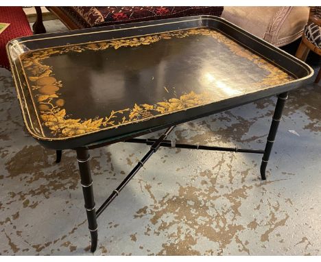 TRAY ON STAND, black lacquer and gilt with foliate and fruit detail on a Regency style base, 58cm x 84cm x 51cm H. (with faul