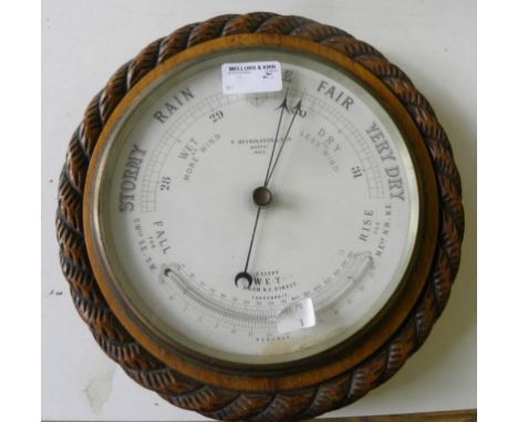 AN EDWARD VII CARVED OAK ANEROID BAROMETER