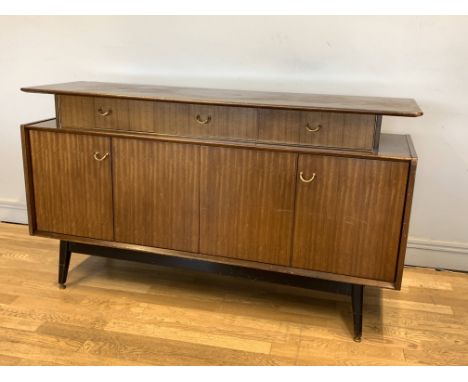 A G-Plan Librenza Tola wood sideboard, by E. Gomme, c.1960's, having a floating shelf over a run of three drawers above bifol