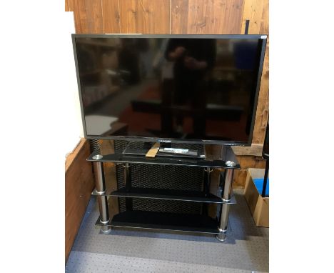 A Blaupunkt (model B40U133T) 49 inch KLED TV, remote and manual, together with a two tier glass shelved TV stand