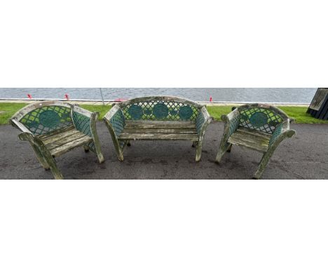 A garden suite, comprising of a two seater bench, a pair of armchairs and an occasional table, painted cast iron fretwork and