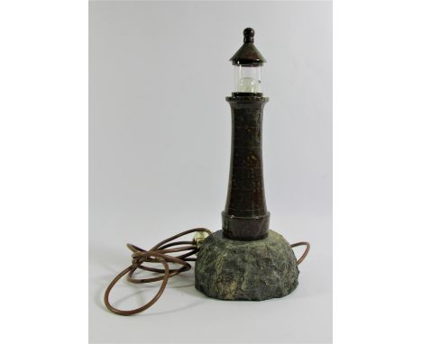 A Cornish serpentine lighthouse table lamp, C1960s, with transparent glass shade, standing on a rocky marble outcrop base. 37