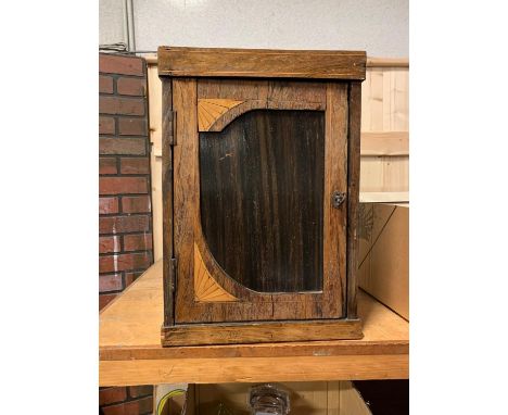 A medicine cabinet, with lightwood inlay decoration, hinged and lockable door, opens to reveal a shelved interior, including 