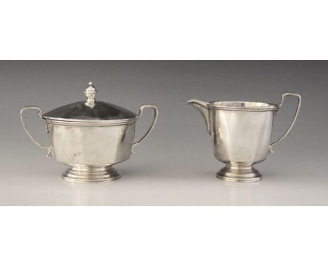 A George V silver milk jug and sucrier, Adie Brothers Ltd, Birmingham 1935, each of tapering faceted form on circular foot an