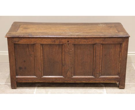 A George II oak coffer, the rectangular moulded top above a frieze inscribed 'B K 1734', over four inverted panels, raised up