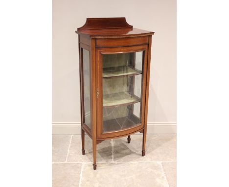 An Edwardian mahogany bow front display cabinet, by Ray and Miles, Liverpool, the raised back above a single convex glazed do