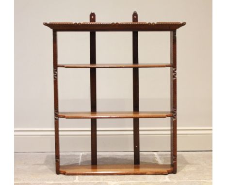 A Folk Art chip carved oak wall shelf, the three shelves with inverted front corners, flanked by uprights with chip carved de