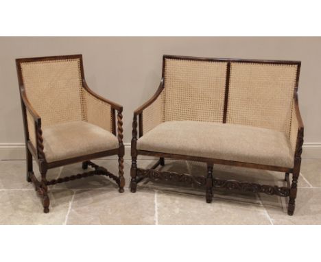 A 1920's stained beech wood bergere two seater settee, the rattan side and back panels enclosing a tweed upholstered seat, ra