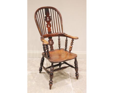 A 19th century ash and elm farmhouse Windsor elbow chair, the hooped back with a pierced splat and pad arms, above the shaped