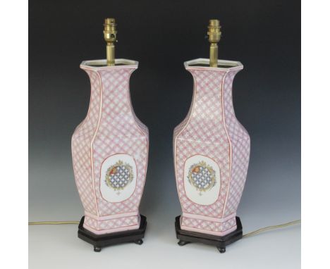 A pair of Chinese export armorial lamp bases, 20th century, each of faceted baluster with pink lattice form decoration, with 
