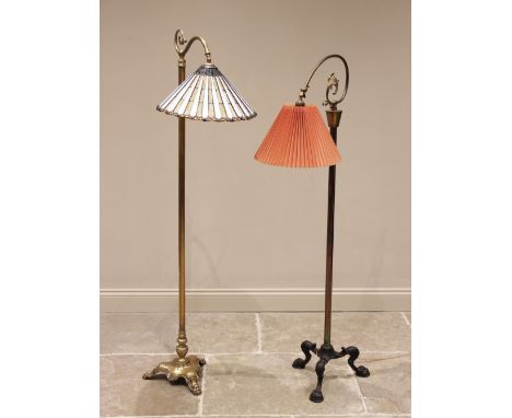 An early 20th century brass standard lamp, the plain cylindrical column extending to a triform plinth base and three cast paw