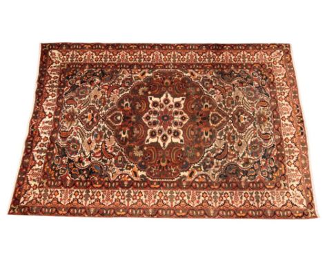 An antique fine woven Persian Bautiar village rug, the vibrant foliate design with central floral medallion enclosed by confo