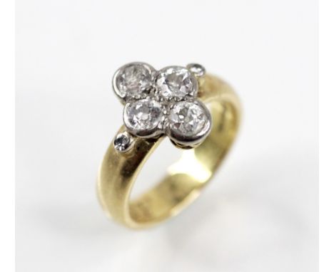 A diamond cluster ring, the central quatrefoil cluster comprising four round old cut diamonds, with a further small mixed cut