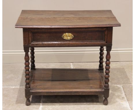 An early 18th century oak side table, the moulded twin board top above a single frieze drawer, raised upon bobbin and block t