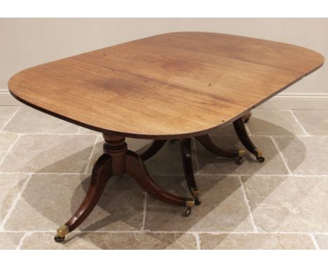A Regency mahogany three pillar dining table, the rectangular top with rounded corners, raised upon baluster and ring turned 