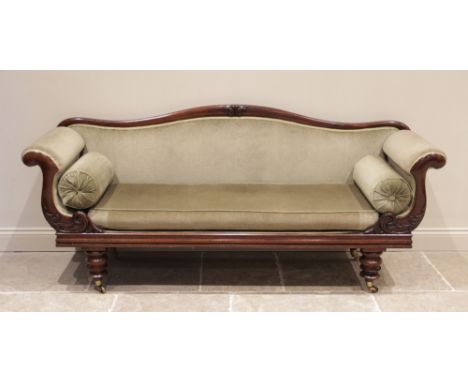 A Victorian mahogany twin scroll end sofa, upholstered in green velour, the serpentine back rail centred with a carved foliat