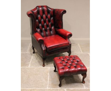 A George III style oxblood red leather wing back office or club chair, late 20th century, the button back with out swept wing