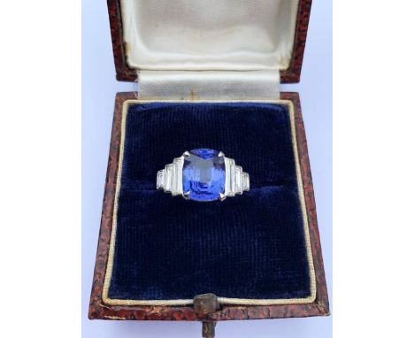 A colour-change sapphire and diamond ring, the central rectangular cushion cut sapphire weighing 5.20 carats (measuring 10.8m