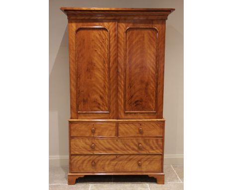 A Victorian satin birch linen press, finished with a tiger stripe patina, the moulded cornice above a pair of cupboard doors 