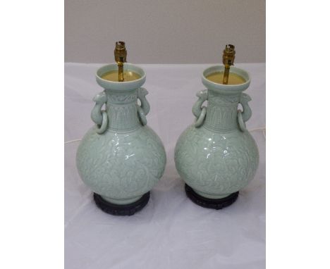 Pair of Chinese celadon glazed lamp bases, raised on hardwood bases, H.42cm