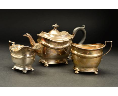 AN EDWARDIAN SILVER THREE PIECE BACHELOR'S TEASET, of oval form, engraved initial 'M' to each piece, gadrooned rims, teapot w