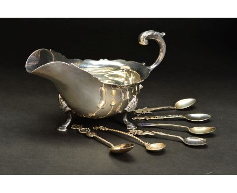 AN EARLY 20TH CENTURY SILVER SAUCE BOAT, of oval form, wavy rim, 'S' scroll handle, on three shell capped cabriole legs with 