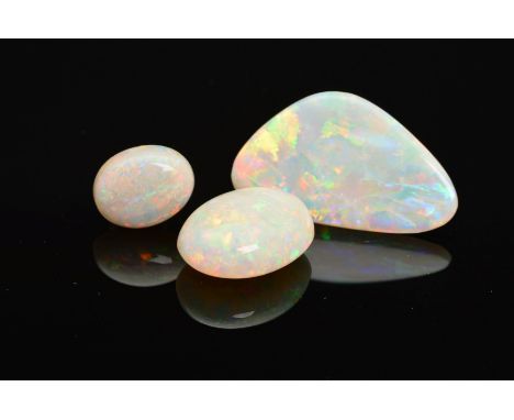 A SELECTION OF THREE PRECIOUS WHITE OPALS, flashes of blues, greens, yellow and orange seen on all, to include two oval caboc