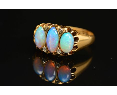 AN EDWARDIAN 18CT GOLD OPAL AND DIAMOND HALF HOOP RING, three oval opal cabochons measuring approximately 8.0mm x 5.00mm, fou