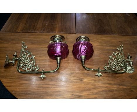 A Pair of Ruby Red Wall Bracket Oil Lamps with Ruby Font and brass filigree and Funnel.