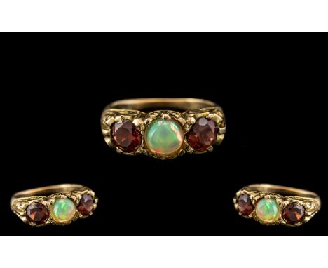 Antique Period - Attractive 9ct Gold 3 Stone Opal and Garnet Set Dress Ring - In a Gallery Setting. The Central Cabochon Cut 