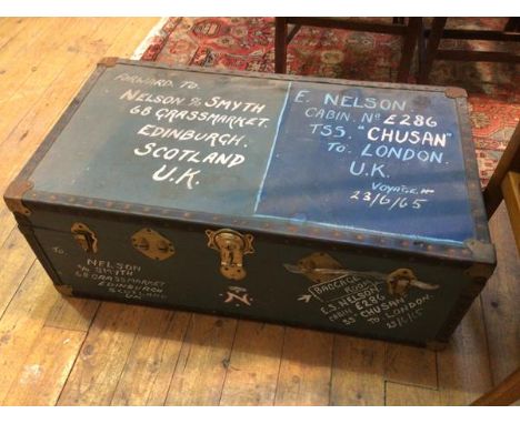 A vintage travelling trunk with inscriptions to exterior and quantity of textiles to interior