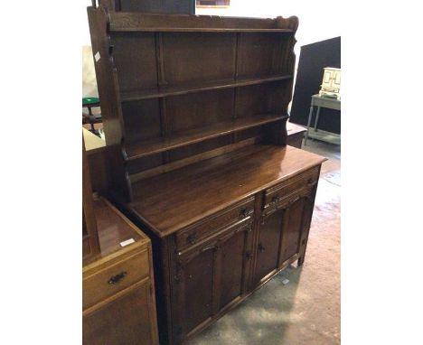 A 1930s/40s mahogany and oak dresser, with three shelf plate rail above a base fitted two frieze drawers and single cabinet w