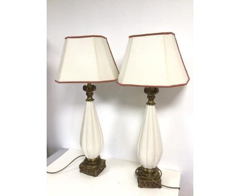 A pair of modern table lamps with ribbed conical shaped ceramic body and gilt metal lamp holder and base, shades cut in half 