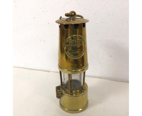 A miners safety lamp by  Protector Lamp and Lighting Company Ltd., inscribed Eccles, Manchester (26cm)