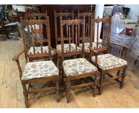 A set of six Ercol elm dining chairs with architectural top rail on spindle back with upholstered seat pads, on turned front 