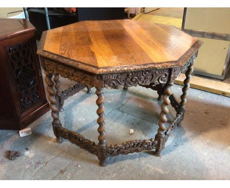 A 1920s/30s oak octagonal centre table with moulded edge above a carved apron, on barley twist supports united by carved stre