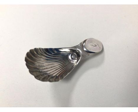 A Georgian Sheffield silver caddy spoon, makers mark N.S.... with shell bowl and initial to handle (7cm)