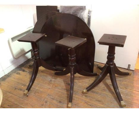 A reproduction Regency mahogany triple pedestal dining table with reeded edges, with multiple leaves, the pedestals with down