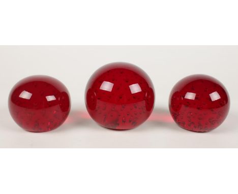 Three ruby red Whitefriars glass paperweights. Largest H: 8cm.  Condition good. No chips or cracks.