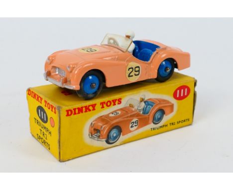 Dinky Toys - A boxed Dinky Toys #111 Triumph TR2 Sports. The model in salmon pink, blue interior, blue hubs, white driver and